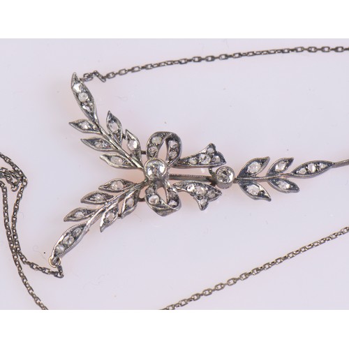 27 - An Edwardian diamond necklace featuring a delicate leaf and bow design, set with diamonds, the large... 