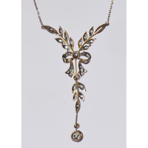 27 - An Edwardian diamond necklace featuring a delicate leaf and bow design, set with diamonds, the large... 