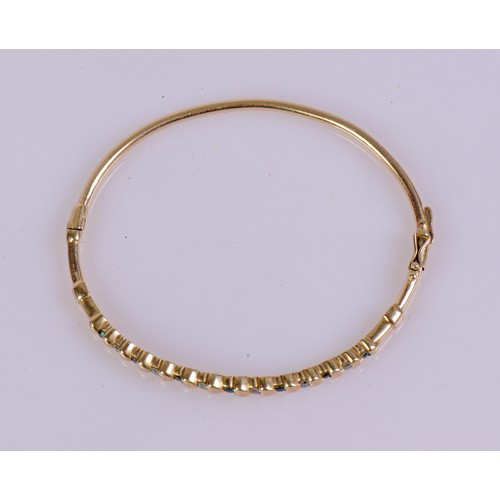 39 - A 9ct gold bangle designed with heart motifs, set with six diamonds and seven emeralds, and fitted w... 