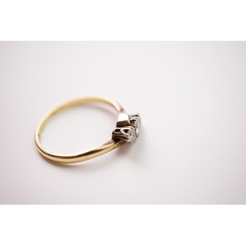 33 - A gold and diamond trilogy ring, set with a central diamond of approximately 0.20ct and two surround... 