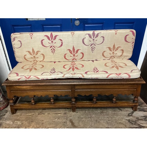652 - An Oak Bench Seat with a Tray Top resting on turned Legs with a Linen Squab. Measuring: 138cms acros... 