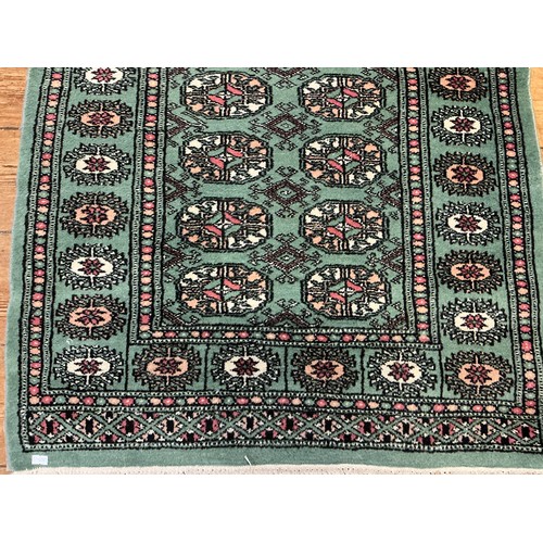 677 - A Green Ground Central 18 Gull, Double Egg Border Persian Carpet/Rug. Measuring: 130cms x 80cms.