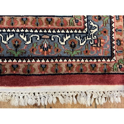 680 - A Burgundy Ground Central Gull decorated Floral Blue Bordered Rug. Measuring: 163cms x 90cms.