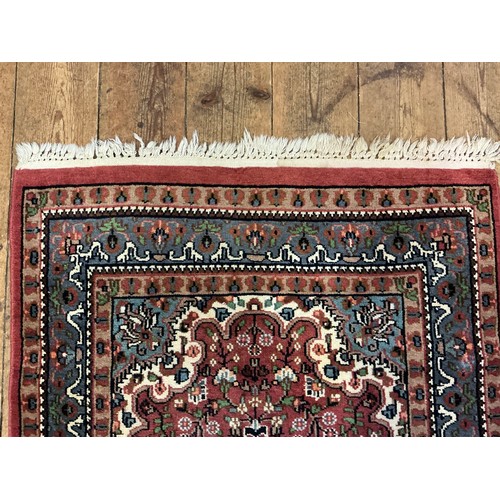 680 - A Burgundy Ground Central Gull decorated Floral Blue Bordered Rug. Measuring: 163cms x 90cms.