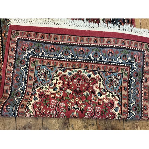 680 - A Burgundy Ground Central Gull decorated Floral Blue Bordered Rug. Measuring: 163cms x 90cms.