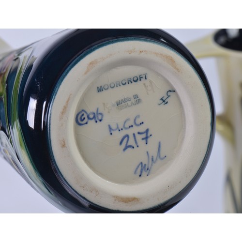 897 - Two White Ground Moorcroft pottery Ewer Jugs Complete with One Box & Paperwork. Measuring: 24cms hig... 