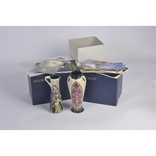 901 - A White ground Moorcroft Jug & a similar Vase Complete with Original Boxes & Paperwork. Measuring: 1... 