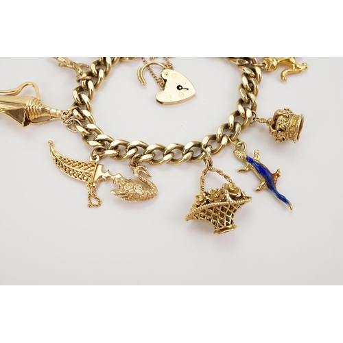 156 - A 9ct gold curb link charm bracelet, fitted with a 9ct gold heart shaped padlock clasp and suspendin... 