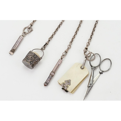 25 - A 1886 silver chatelaine by Lawrence Emanuel, the chatelaine is hung with a pair of scissors, silver... 
