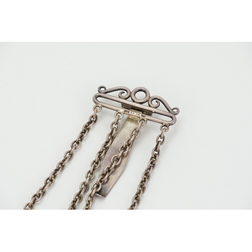 25 - A 1886 silver chatelaine by Lawrence Emanuel, the chatelaine is hung with a pair of scissors, silver... 