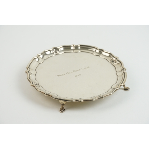 26 - A George V silver salver by Mappin & Webb, hallmarked 1929, with a shaped border and raised on three... 
