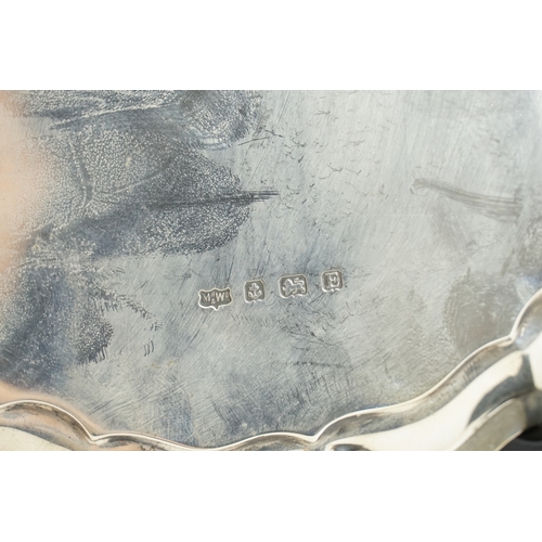 26 - A George V silver salver by Mappin & Webb, hallmarked 1929, with a shaped border and raised on three... 