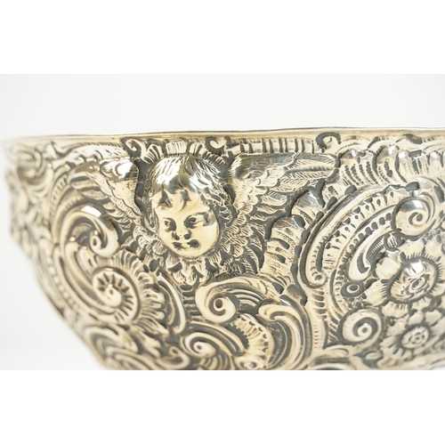 27 - A late 19th-century Anglo-Indian silver bowl, richly worked in repoussé with winged cherubs and flor... 