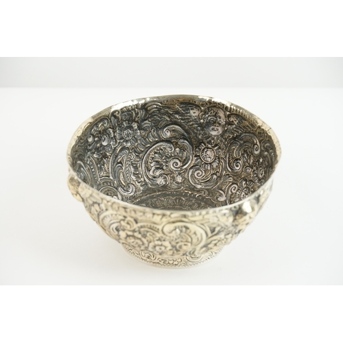 27 - A late 19th-century Anglo-Indian silver bowl, richly worked in repoussé with winged cherubs and flor... 