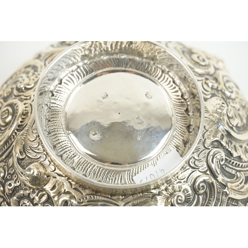 27 - A late 19th-century Anglo-Indian silver bowl, richly worked in repoussé with winged cherubs and flor... 