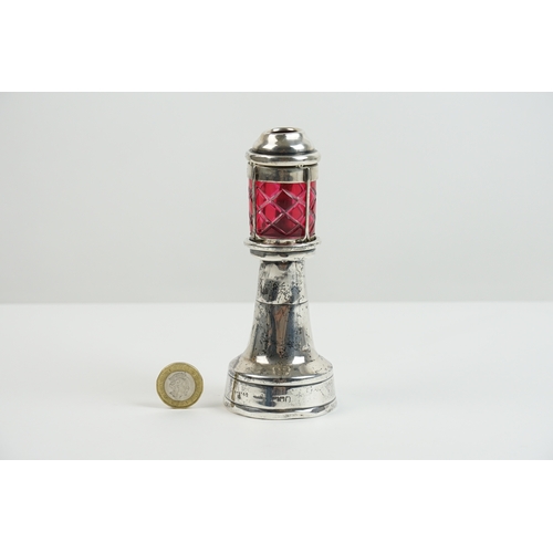 55 - A interesting silver oil lamp, designed as a lighthouse. The lighthouse features ruby coloured glass... 