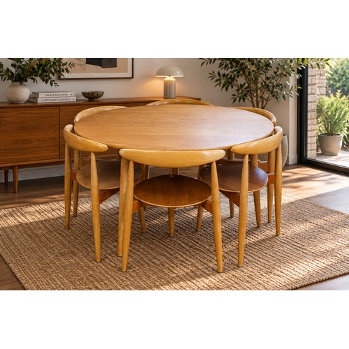 A Danish "Fritz Hansen" Circular Plywood Topped Table resting on three swept out legs & a Set of Six Stackable Three Legged Chairs in Beech with a front pegged leg & maple seats, stamped to base "Fritz Hansen".