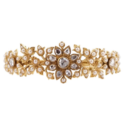 A high carat gold rose cut diamond and seed pearl set bracelet, in a floral leaf design, safety chain hung with a three leaf clover. Set with three large diamonds and 8 smaller diamonds. Largest diamond approx 5.3mm x 5.3mm. Weight 23.7g. (No.6) Owned by..