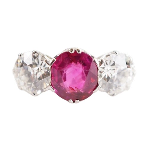 An Art Deco platinum ruby and diamond three stone ring, centrally claw set with an oval cut ruby, approximately 2.00 carats, flanked by two brilliant cut diamonds, each approximately 1.10 carats. The ring is stamped “PT” and weighs approximately 3.8 grams. Ring size L.

Approximate stone measurements:
Left diamond: 6.83mm diameter x 1.53mm crown height x 4.13mm depth
Right diamond: 6.79mm diameter x 1.28mm crown height x 4.04mm depth
Ruby: 7.18mm x 8.00mm x 0.90mm crown height x 4.30mm depth