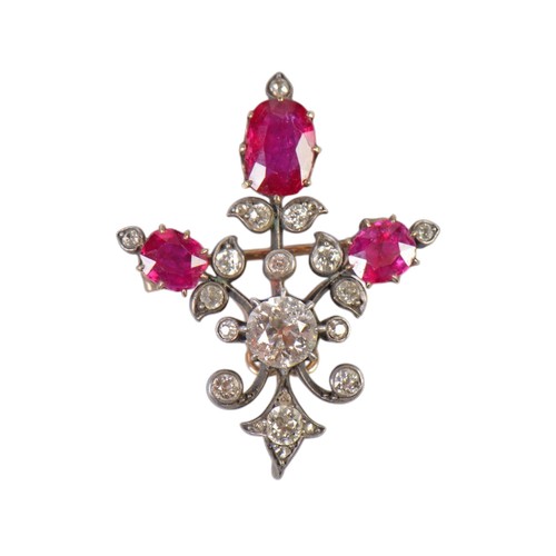 A 19th Century ruby and diamond set brooch, featuring three oval cut rubies and numerous diamonds. The largest central diamond is approximately 0.85ct. The central ruby is approximately 1ct. The setting is an intricate open work frame that tests as 9ct gold silver top. The brooch features a pendant attachment. Weight 6.4g. The size of the rubys from left to right are:
Left - 4.8mm x 5.5mm
Middle - 5.9mm x 8.3mm
RIght - 5.6mm x 5.8mm