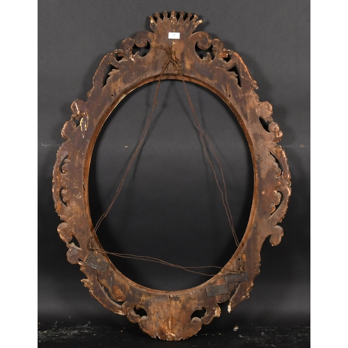 391 - 19th Century Italian School. An Ornate Oval Carved Giltwood Florentine Frame, rebate 29” x 23” (73.7... 