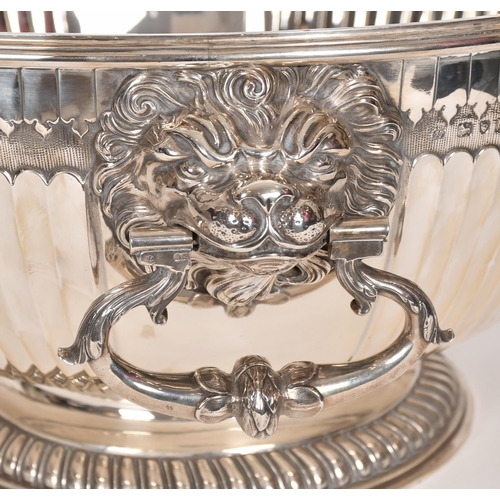 357 - An extremely large Victorian silver punch bowl with lion mask handles and relief decoration, by Jame... 