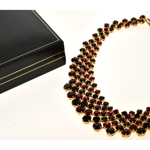 338 - Trifari: A Costume Gilt Black and Red Paste Bib Necklace, graduated and articulated with circular-cu... 