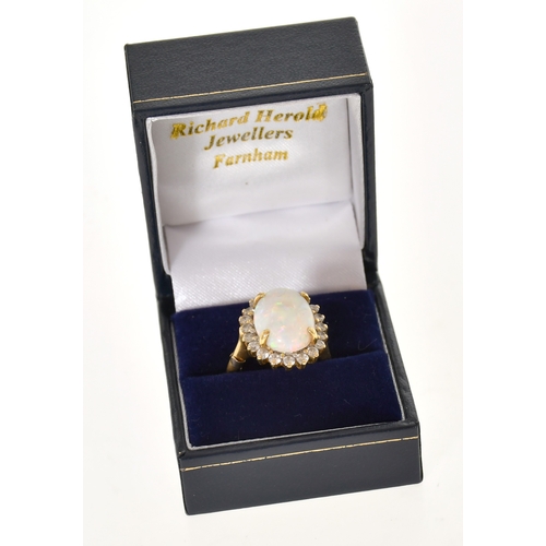 352 - An 18ct Gold Opal and Diamond Cluster Ring, four claw set with a cabochon opal measuring 15.4mm x 11... 