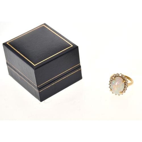 352 - An 18ct Gold Opal and Diamond Cluster Ring, four claw set with a cabochon opal measuring 15.4mm x 11... 