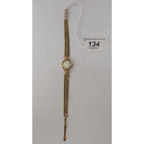 134 - A lady's 9ct gold cased bracelet watch, faced by a baton dial 