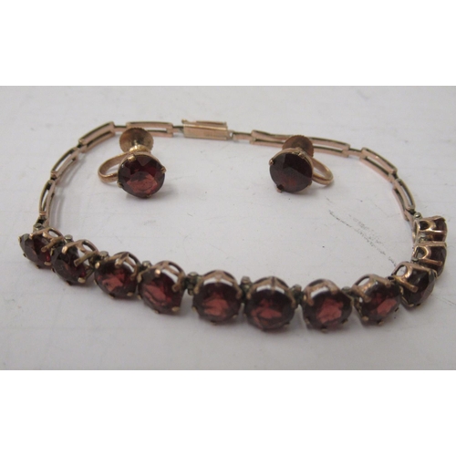 330 - A suite of yellow metal jewellery set with faceted garnets, viz. a bracelet and a matching pair of c... 