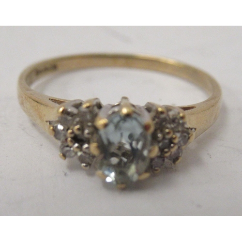 333 - A 9ct gold ring, set with a central aquamarine, flanked by small diamonds  