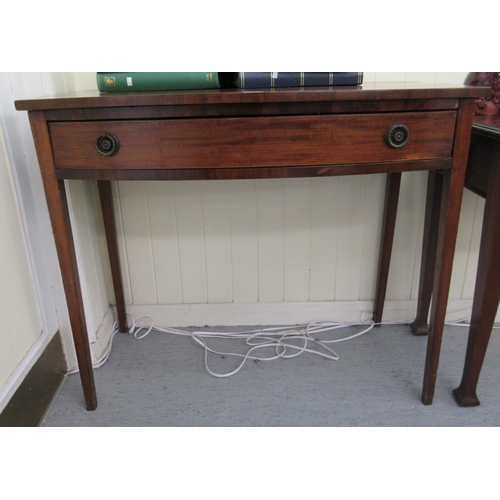 334 - An early 19thC mahogany bow front side table with a frieze drawer, raised on square, tapered legs&nb... 