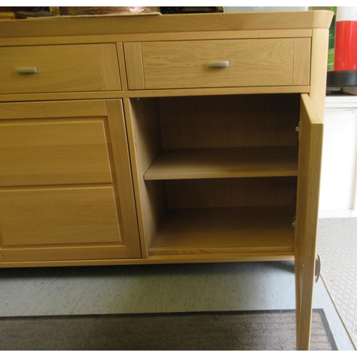 60 - A modern Continental panelled, light oak sideboard with round corners, comprising three inline drawe... 