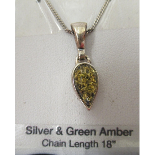 91 - A pair of silver and green amber set earrings and a matching silver pendant, on a fine neckchain; an... 