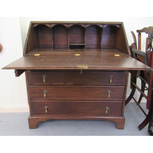 102 - A 1930s oak bureau, the fall flap over four graduated drawers, raised on bracket feet  39.5