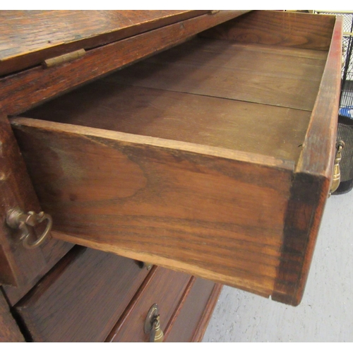 102 - A 1930s oak bureau, the fall flap over four graduated drawers, raised on bracket feet  39.5