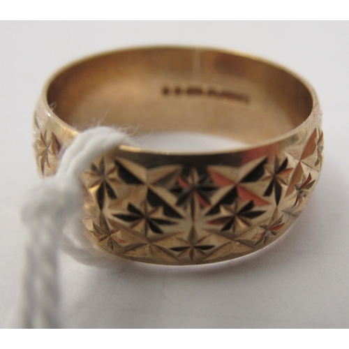 151 - A 9ct gold band ring with chiselled ornament