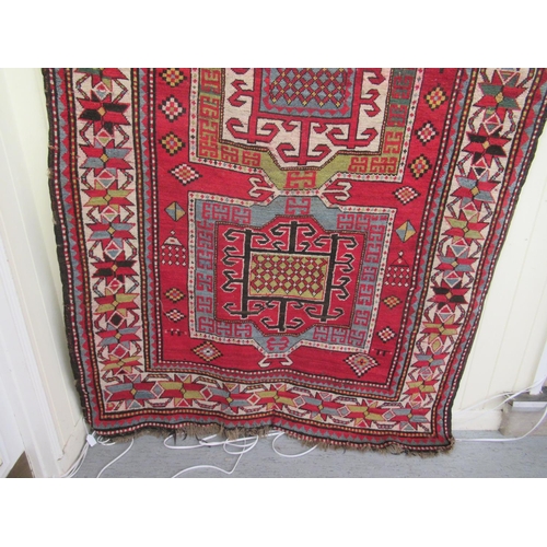 178 - An Afghan Kazak rug, decorated with repeating geometric designs, on a cream ground  52