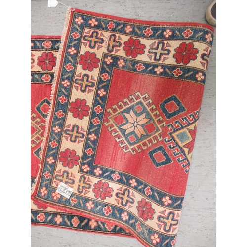 188 - An Afghan Kazak runner, decorated with repeating central diamond shaped motifs, on a multi-coloured ... 