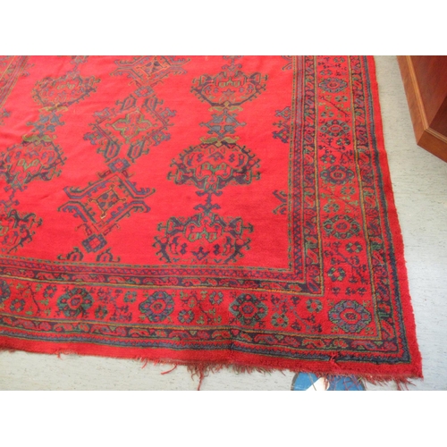 190 - A Persian carpet, decorated with stylised designs, on a red ground  140