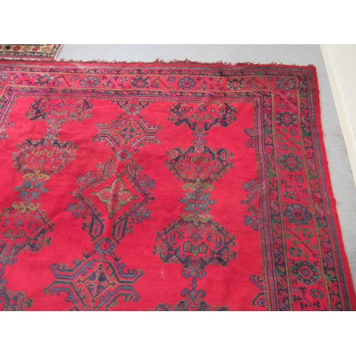 190 - A Persian carpet, decorated with stylised designs, on a red ground  140