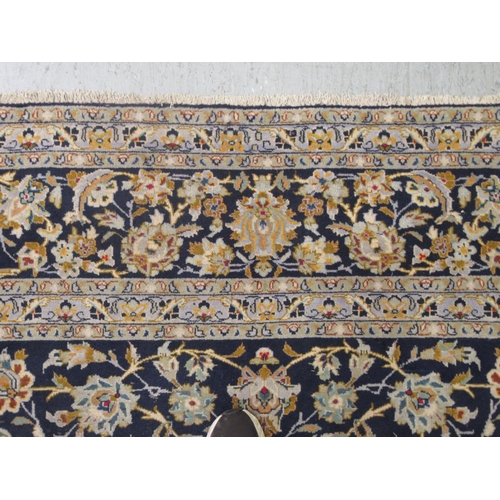 191 - A Keshan carpet, decorated with dense floral motifs, on a blue ground  157