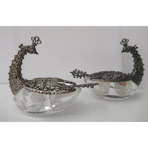 77 - A pair of salt cellars, each fashioned as a Bird of Paradise, the cut glass bowls surmounted by a si... 