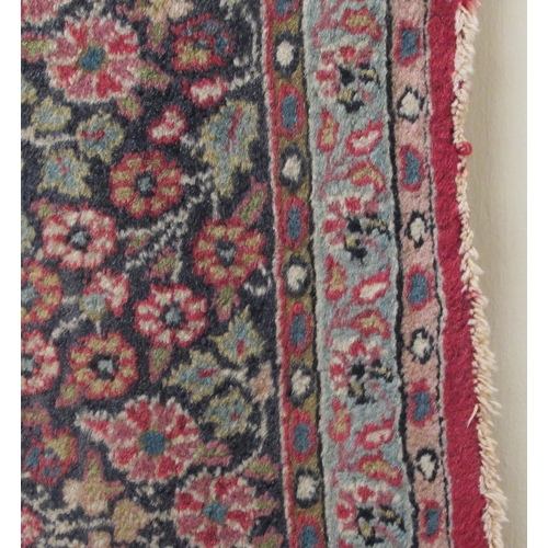 180 - A Persian rug, decorated with a central starburst design medallion, bordered by floral designs, on a... 