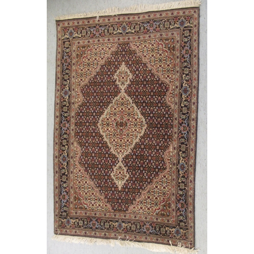 102 - A part silk woven Tabriz rug, decorated with flower head and other stylised designs, on a multi-colo... 