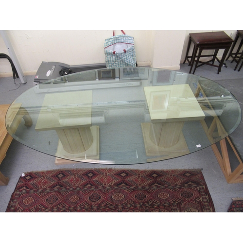 118 - A modern glass top dining table of oval form, raised on two cream coloured painted pillar design ped... 