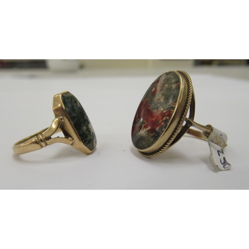 119 - Two dissimilar gold coloured metal and agate set dress rings 