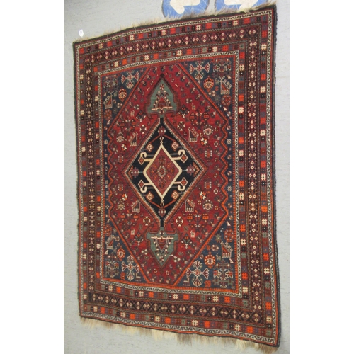 125 - A Shiraz rug, decorated with symmetrical stylised designs, on a multi-coloured ground  47