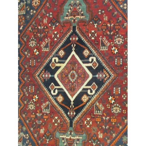 125 - A Shiraz rug, decorated with symmetrical stylised designs, on a multi-coloured ground  47